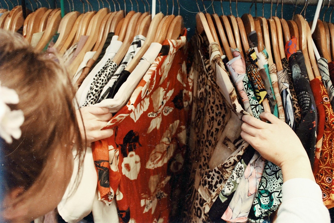 Girl in small closet checking clothes.